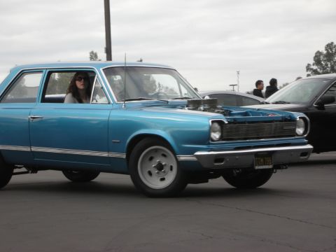 1998 Ford Crown Victoria - Blue 1967 AMC Rambler American 4-door sedan with hood open, driver visible. Another car is parked next to it.