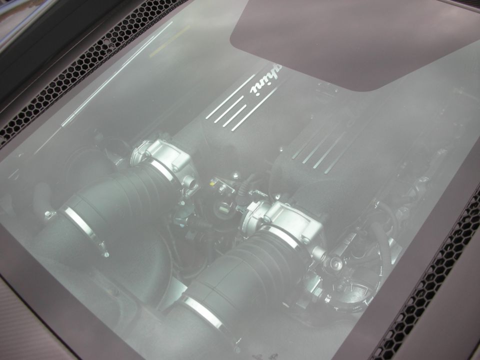 Mid-engine V8 viewed through a car's rear glass engine cover