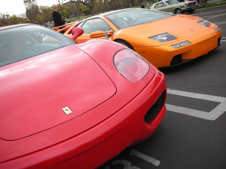 Red Ferrari and orange Lamborghini Diablo parked at a car meet