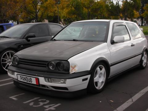 1998 Ford Crown Victoria - A modified Volkswagen Golf Mk3 is seen from the front-three-quarter angle in a parking lot.