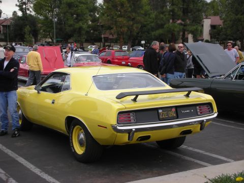 1998 Ford Crown Victoria - Rear view of a yellow 1970 Plymouth Barracuda at a car show with other vehicles present.