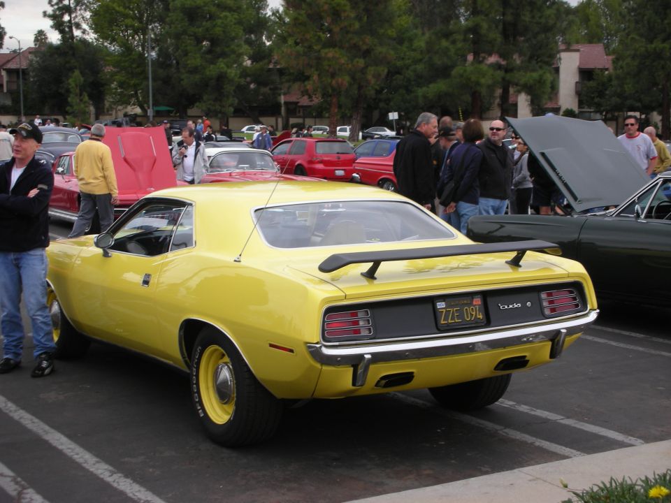 Yellow 1970 Plymouth Barracuda with a rear spoiler and a license plate reading ZZE 094