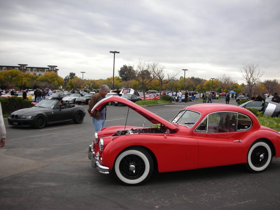 Red coupe with hood open, white wall tires, wire wheels, and chrome trim