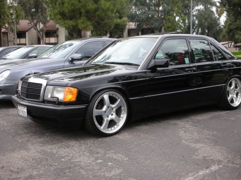 1998 Ford Crown Victoria - A black Mercedes-Benz 190E is parked in a lot, showing off its aftermarket wheels.