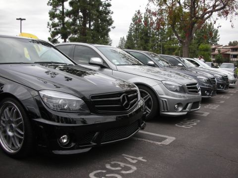 1998 Ford Crown Victoria - A line of Mercedes-Benz C-Class sedans parked in a lot under an overcast sky.