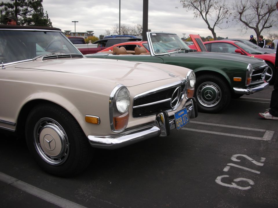 Cream Mercedes convertible in front of green Mercedes convertible and red sports car