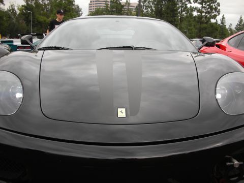 1998 Ford Crown Victoria - Black Ferrari 360 Modena with racing stripes, parked next to a red Ferrari.