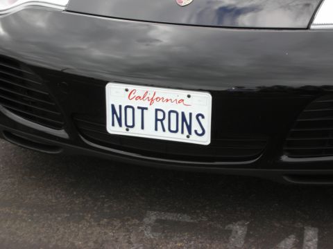 1998 Ford Crown Victoria - California license plate on a black car reads 'NOT RONS'.