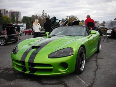 1998 Ford Crown Victoria - A bright green convertible with black racing stripes is parked with its doors open at an outdoor event.