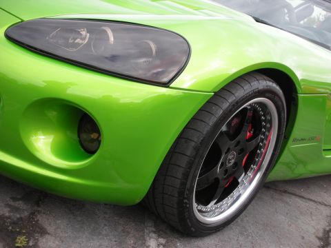 1998 Ford Crown Victoria - Close-up of a lime green sports car's front fender, headlight, and wheel, showing custom modifications.