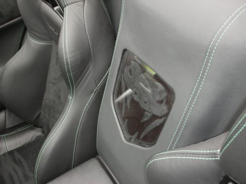 1998 Ford Crown Victoria - The interior of a car features black leather seats with distinctive green stitching and a snake emblem visible through a clear panel.