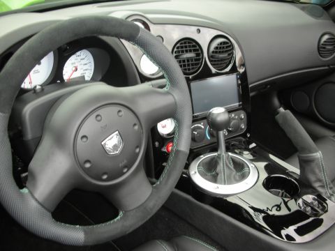 1998 Ford Crown Victoria - The interior of a car features a steering wheel with a snake emblem and a manual gear shift.