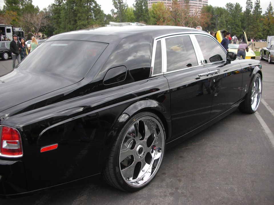 Black sedan with chrome rims, rear quarter view