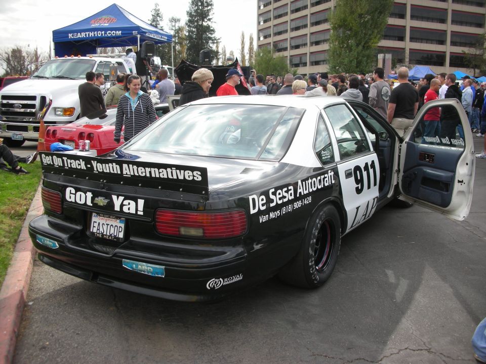 Rear view of a black and white police car with racing slicks and a large spoiler. Text reads 'Got Ya!' and 'FASTCOP'