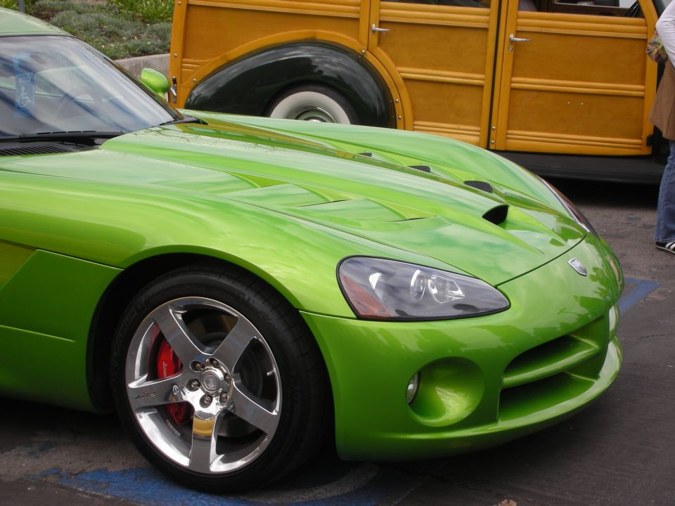 Front corner of a bright green Dodge Viper parked next to a yellow woodie wagon