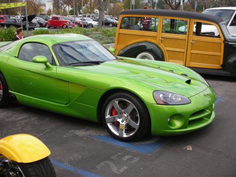 1998 Ford Crown Victoria - A bright green sports car is parked in a lot next to a classic woodie wagon and other vehicles.