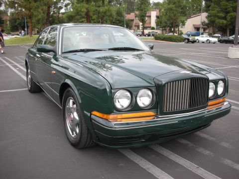 1998 Ford Crown Victoria - Photograph of a dark green Bentley sedan front three-quarter view showing grille and quad headlights.