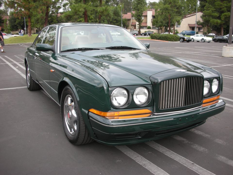 Front three-quarter view of a green Bentley sedan in a parking lot