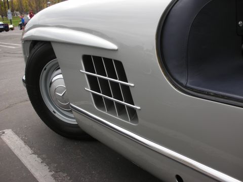 1998 Ford Crown Victoria - Photograph of the chrome side fender vent and front wheel of a silver Mercedes-Benz 300SL.