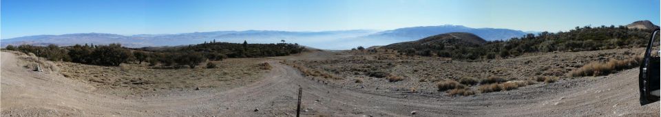 Panoramic view of a dirt road across high desert terrain