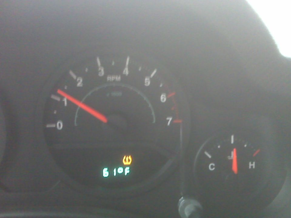 Jeep gauge cluster: tach near 1000 RPM, TPMS warning light, 61°F display, temp gauge reading high
