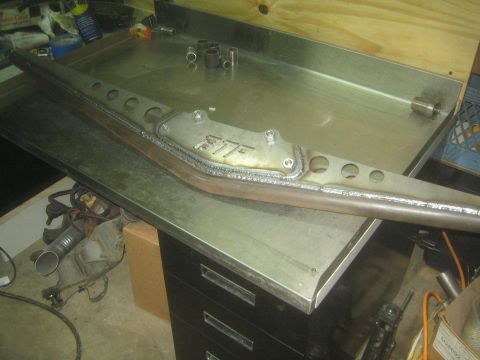 1990 Ford Bronco - Photograph of a fabricated and welded steel frame member with an FTF gusset on a shop table, not a document.