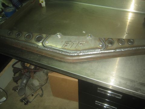 1990 Ford Bronco - Photograph of a long fabricated steel frame member with FTF gusset and lightening holes, not a document.
