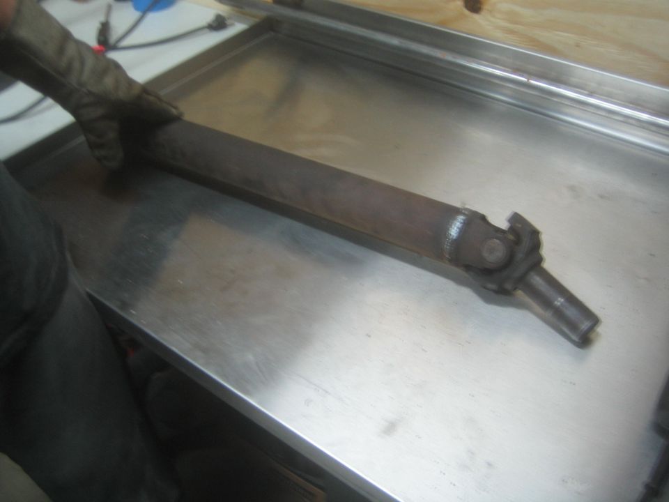 Driveshaft with U-joint lying on a metal workbench