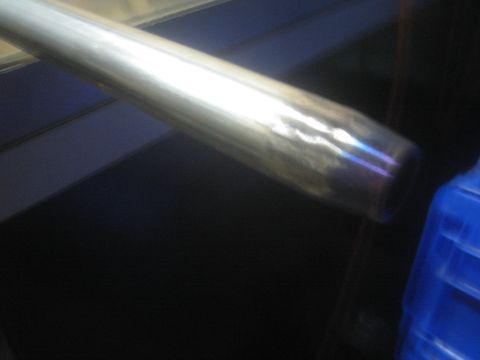1987 Suzuki Samurai - Photo of a polished metal tube or driveshaft section lying on a dark work surface.