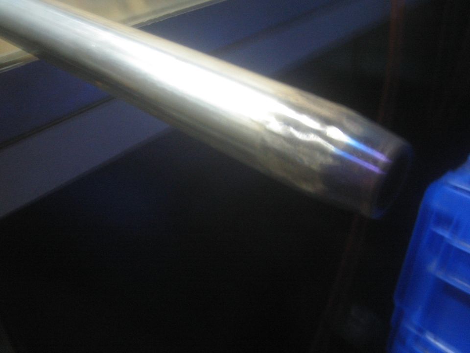 Polished metal tube or driveshaft on a workbench