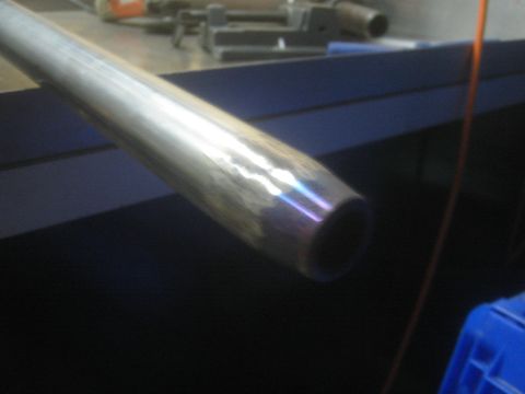 1987 Suzuki Samurai - Photo of a shiny metal tube or shaft on a dark bench beside tools and a blue storage bin.