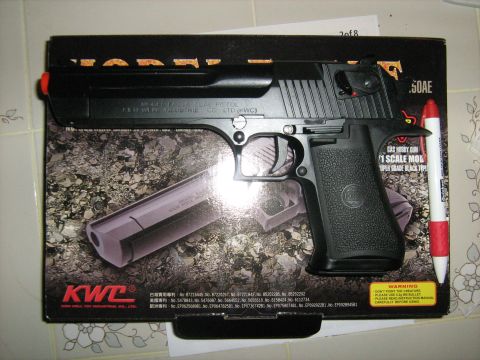 1988 Mercury Grand Marquis - A black toy gun, likely a replica of a Desert Eagle .50 AE pistol, is displayed on its original packaging. The box features graphics of the…