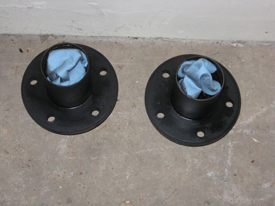 Two black painted wheel hubs stuffed with shop towels