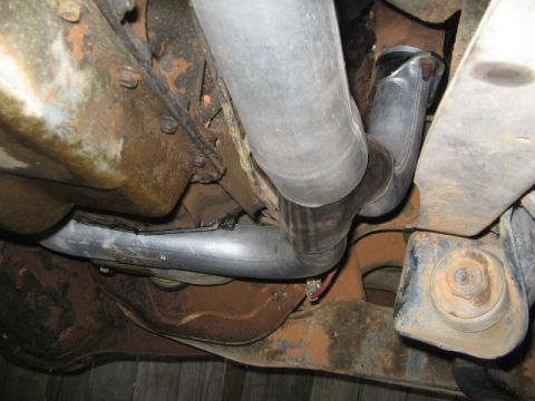 1991 Ford Bronco - Close-up of exhaust system parts and chassis elements.