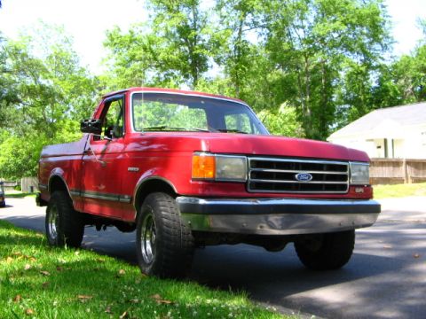 1991 Ford Bronco - This red Ford pickup truck, seen from a 3q-front angle, features styling consistent with the early 1990s model years.