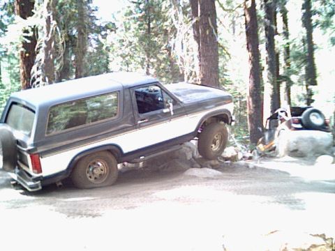1985 Ford Bronco - Ford Bronco navigating rocky terrain with another vehicle visible in the background.