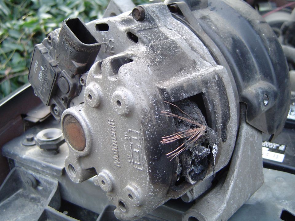 Close-up of a burnt alternator with visible copper wires and a "Motorcraft" label