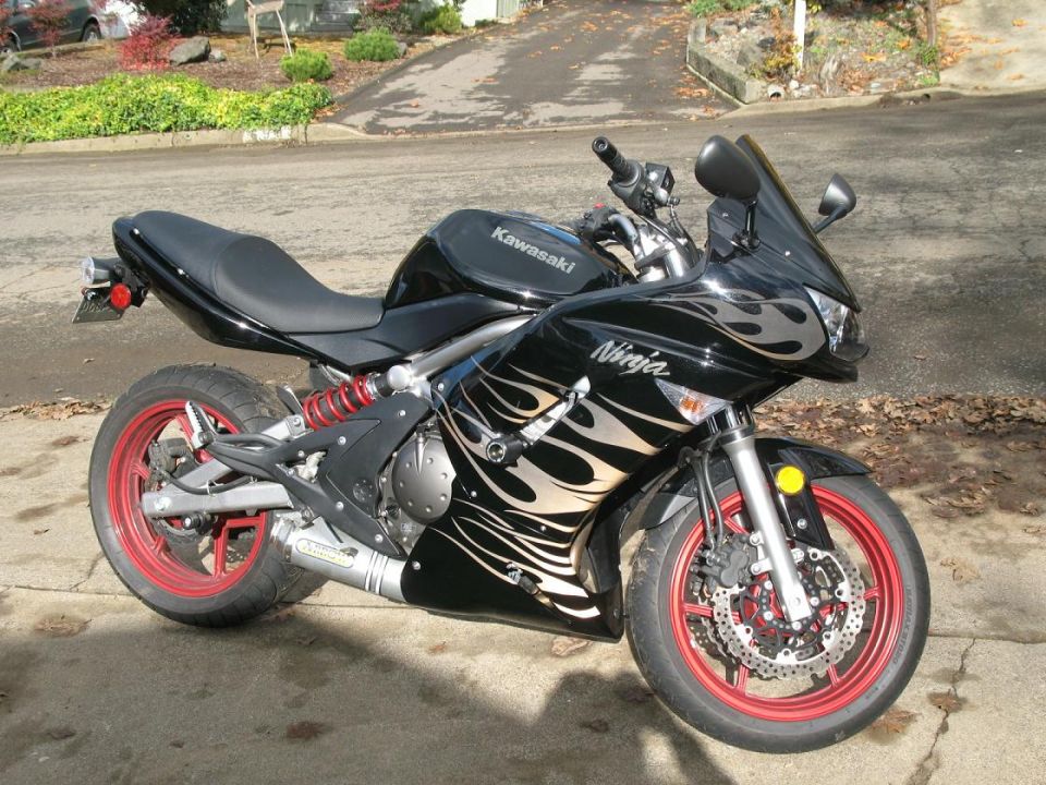 Black Kawasaki Ninja motorcycle with red rims and flame graphics.