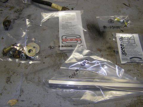 1993 Ford Bronco - Several plastic bags containing hardware and a metal bar are laid out on a concrete surface. One bag contains bolts and washers labeled '90…