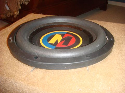 1996 Ford Bronco - A car subwoofer with a prominent 'M' logo is shown resting on a carpeted surface.