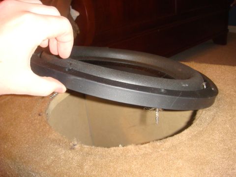 1996 Ford Bronco - A speaker is being installed into a custom enclosure, likely for a car audio system.