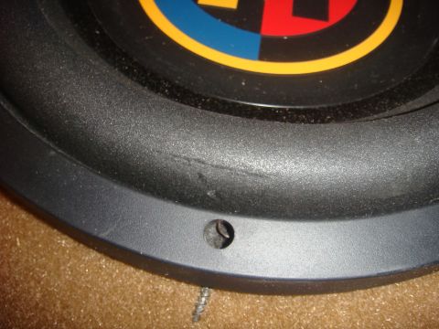 1996 Ford Bronco - Close-up of a subwoofer speaker showing its cone and a colorful logo. The Supermotors.net watermark is visible at the bottom right.