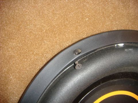 1996 Ford Bronco - A close-up view shows the edge of a black speaker with two screws visible, mounted against a textured brown surface.