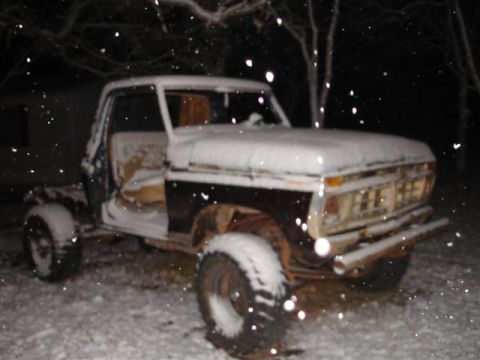 1996 Ford F-150 - A snow-covered 1973 Ford F-150 truck sits outside in the snow at night.