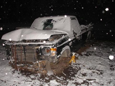 1996 Ford F-150 - A damaged 1996 Ford F-150 sits covered in snow during a winter storm.
