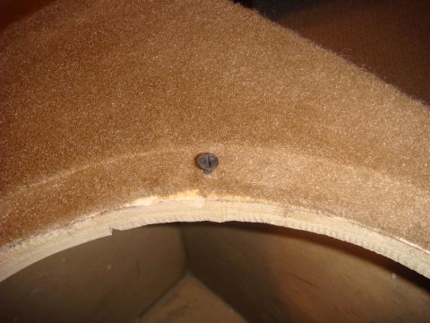 1996 Ford Bronco - Close-up view of a tan interior trim panel, secured with a single screw.