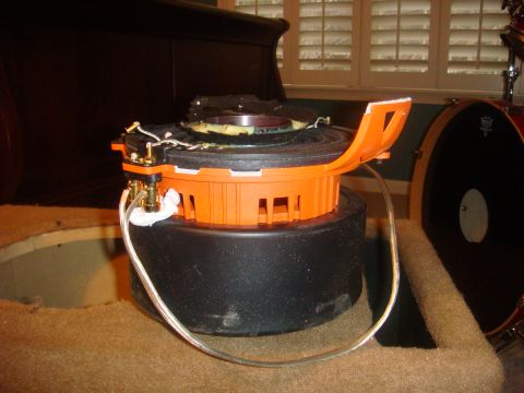 1996 Ford Bronco - A car speaker is shown with wiring, possibly for installation or repair, with a drum set visible.