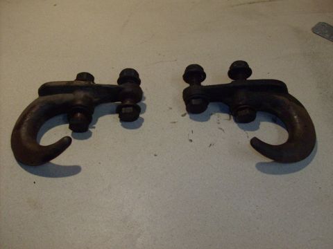 1978 Ford Bronco - Two rusty tow hooks are shown mounted on a flat surface.