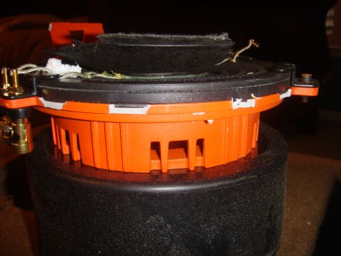 1996 Ford Bronco - A close-up view of a damaged speaker component, showing its internal structure and wiring.