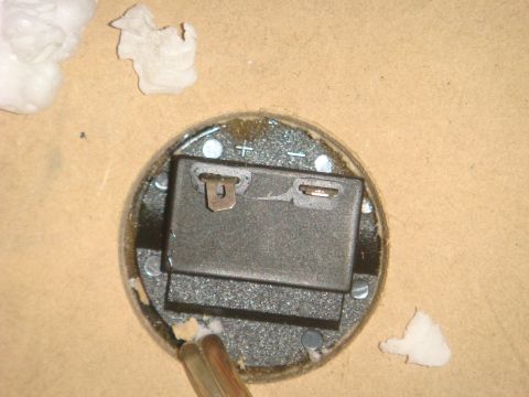 1996 Ford Bronco - Internal view of a gauge's battery compartment, showing the positive and negative terminals.